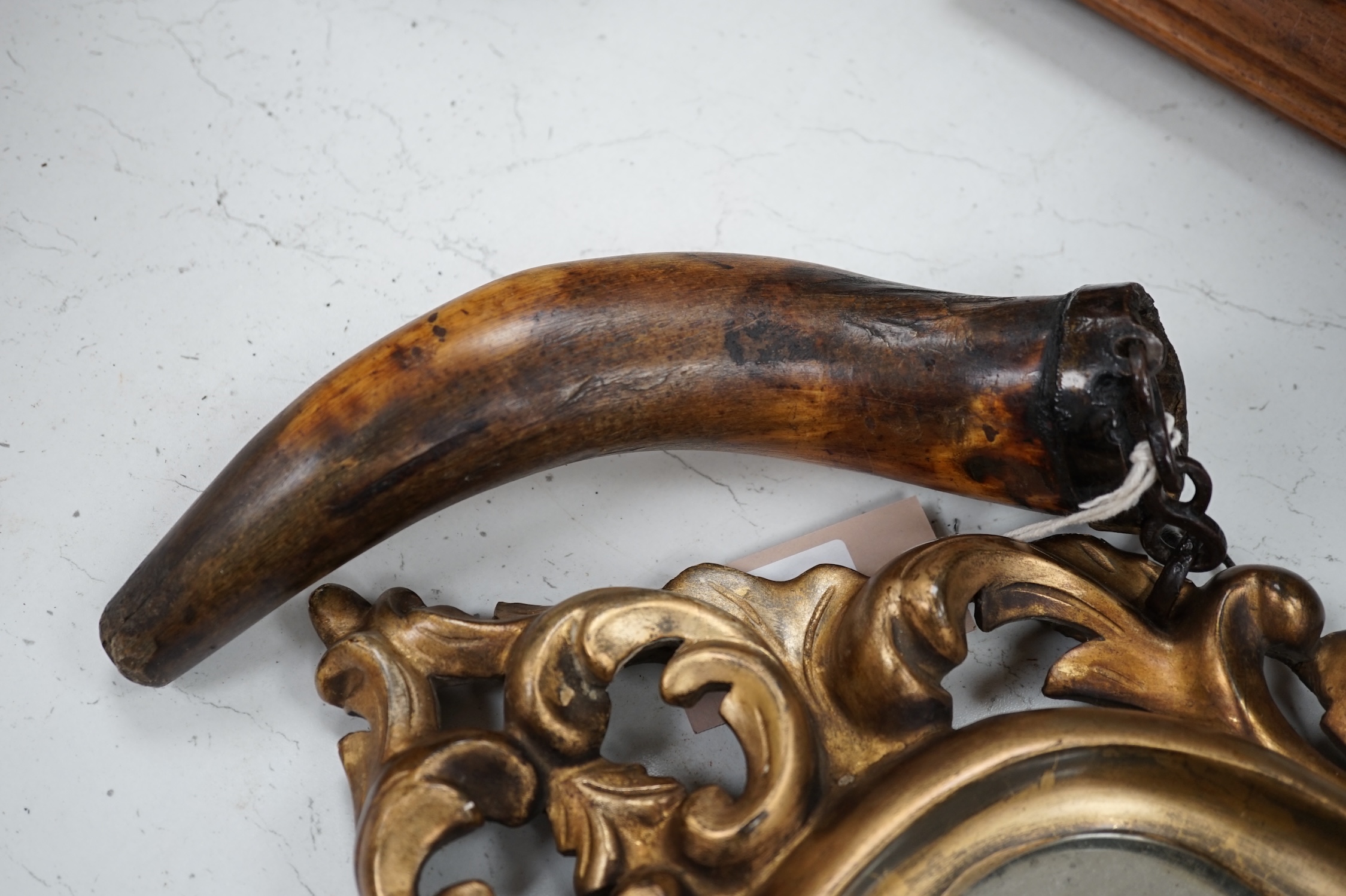 A 19th century giltwood mirror, a powder horn and a pair of tribal carved wood figures, mirror 55cm long. Condition - fair to good